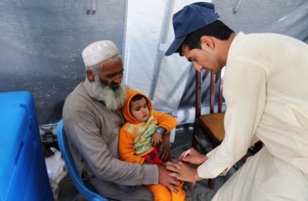 12._Razi_Khan_holds_his_daughter_Asma_as_she_gets_the_injectable_inactivated_polio_vaccine_IPV_at_the_IOM_transit_centre_near_the_Torkham_border 12._Razi_Khan_holds_his_daughter_Asma_as_she_gets_the_injectable_inactivated_polio_vaccine_IPV_at_the_IOM_transit_centre_near_the_Torkham_border