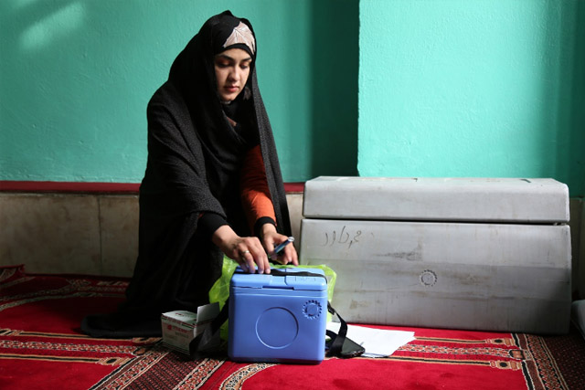 In the morning, the blue boxes used to keep vaccine vials cold were packed and picked up by the vaccination teams. Shireen Gul Azizi packed her bags before leaving for the day’s work. She works as a supervisor, and manages three vaccinator teams.