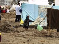 A child in Abe Barek plays with a kite made out a plastic bag