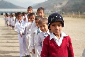 Children standing in a long queue to get vaccinated