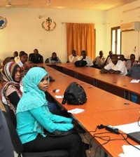 A group of trainees sitting at a u-shaped table while receiving training 