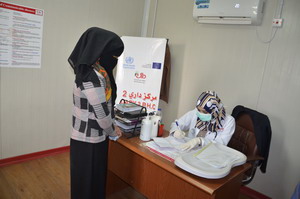 A doctor prescribing treatment to a patient at primary healthcare facility in Ninewa governorate 