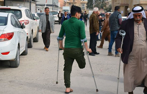 Ahmed Jamil makes his way down the street with the use of crutches 