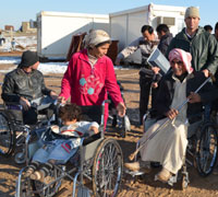Syrian refugees receiving wheelchairs in the Domiz camp