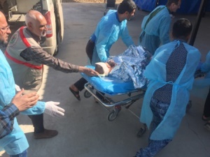 A patient being pushed by medical staff on a medical stretcher on wheels