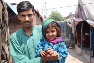 A father and daughter proudly show off the purple dot of ink on her little finger to show that she has been vaccinated against polio in the May campaign. WHO Pakistan/Anam Khan