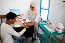 A patient receiving his unit dose under supervision from a treatment supporter 